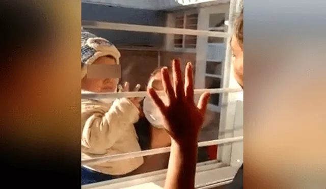 Una mujer con coronavirus debe saludar a su hijo a través de una ventana para no contagiarlo. Foto: Facebook