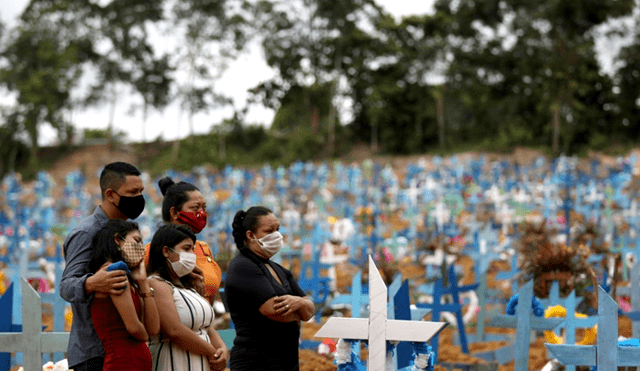 Personas asistiendo al entierro de un familiar fallecido con coronavirus en el cementerio Parque Taruma en Manaos, Brasil. | Foto: Bruno Kelly