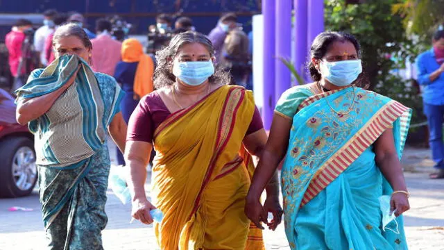 Residents and hospital visitors wearing facemaks walk outside the Government Medical College in Thrissur on January 30, 2020, where the first confirmed case of the SARS-like virus in India is kept in isolation. - Officials on January 30 confirmed the first case in Kerala, southern India. The woman, a student at Wuhan University, is in isolation at a hospital. Authorities said they were stable and being closely monitored. (Photo by STR / AFP)