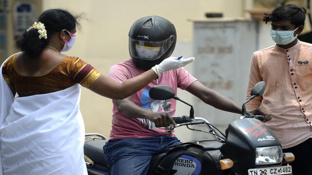 A health worker stops motorists to take swab samples for testing for the Covid-19 coronavirus at a testing camp in a residential area, in Chennai on August 30, 2020. - India on August 30 set a coronavirus record when it reported 78,761 new infections in 24 hours -- the world's highest single-day rise -- even as it continued to open up the economy. (Photo by Arun SANKAR / AFP)