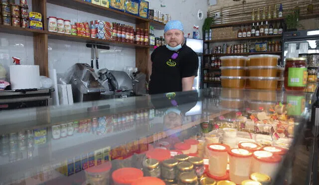 Cijay Brightman poses for a photo in Tel Aviv, Israel, Monday, July 13, 2020. A year ago, Brightman was doing sound and lighting for a Madonna performance in Israel. Now, after the coronavirus wiped out live events, he's making sandwiches, slicing cheese and serving customers at a Tel Aviv deli. (AP Photo/Sebastian Scheiner)