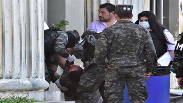 Un grupo de policías militares carga el cuerpo sin vida de un compañero asesinado. Foto: EFE