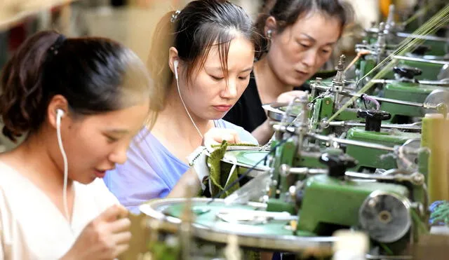 This photo taken on August 13, 2018 shows employees working on a production line of clothes for export at a factory in Xiayi county, in Shangqiu in China's central Henan province. - Key economic readings released on August 14 in China showed investment slumping to a record low for the first seven months of the year as retail sales slowed, pointing to weakness in the world's second largest economy. (Photo by STR / AFP) / China OUT