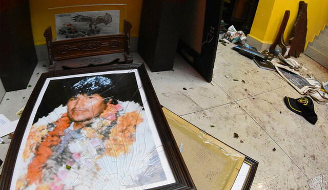 En el piso de la casa destrozada de Evo Morales, yace su retrato con el vidrio roto. Foto: AP.