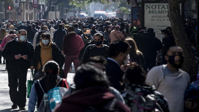 People wear face masks while walking along a pedestrian promenade in downtown Santiago, following the easing of lockdown restrictions amid the Covid-19 pandemic, on August 17, 2020. (Photo by MARTIN BERNETTI / AFP)