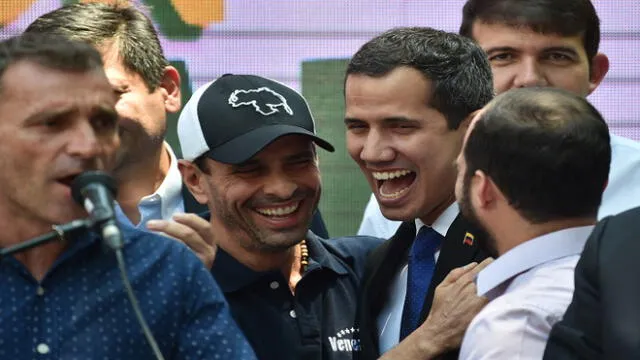 Venezuelan opposition leader and self-proclaimed interim president Juan Guaido (C-R) shares a laugh with also opposition leader Henrique Capriles (C-L) as they and local and regional leaders address the crowd to give details of what Guaido calls "Operation Freedom" during a rally in Caracas on March 27, 2019. - Desperation and rage spreads among Venezuelans as the hours pass and the massive blackout that hits the country since Monday is not solved. A new blackout swept across Venezuela on Monday, including much of Caracas, sowing alarm two weeks after a nationwide outage that paralyzed the country. (Photo by Yuri CORTEZ / AFP)