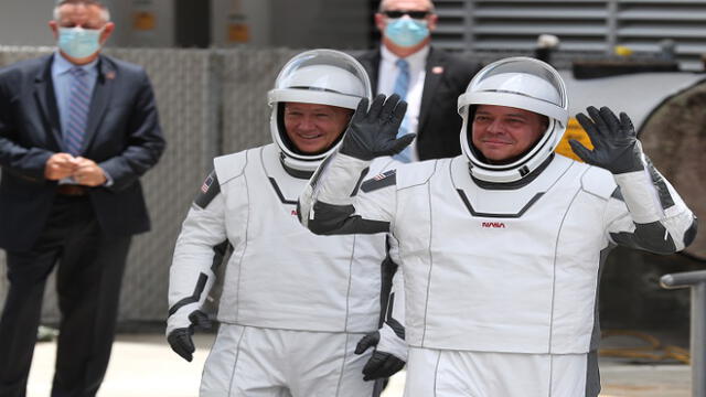 CAPE CANAVERAL, FLORIDA - MAY 27: NASA astronauts Bob Behnken (R) and Doug Hurley (L) walk out of the Operations and Checkout Building on their way to the SpaceX Falcon 9 rocket with the Crew Dragon spacecraft on launch pad 39A at the Kennedy Space Center on May 27, 2020 in Cape Canaveral, Florida. The inaugural flight will be the first manned mission since the end of the Space Shuttle program in 2011 to be launched into space from the United States.   Joe Raedle/Getty Images/AFP
