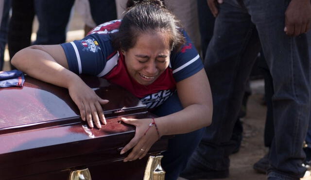 Madre enterrando a su hijo a causa de una bala perdida durante un enfrentamiento entre narcotraficantes. Foto: AFP