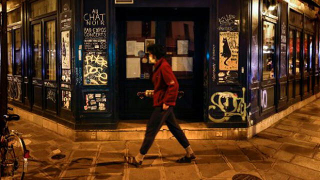 Mujer camina por las calles de Francia protegida con una mascarilla. Foto: AFP