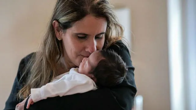 Luciana Lira con el pequeño Neysel, a quien acogió ante la enfermedad de su madre. Fuente: Getty Images.