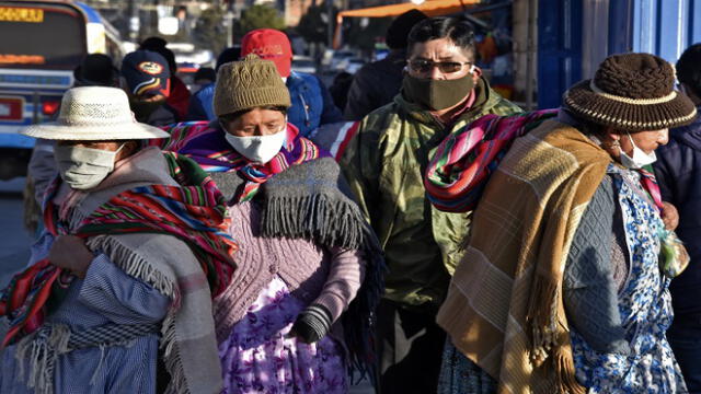 People wearing face masks walk in the streets of El Alto as Bolivia eases its lockdown to reactivate the economy amid the COVID-19 novel coronavirus pandemic, on June 1, 2020. - The pandemic has killed 373,439 people worldwide since it surfaced in China late last year, according to an AFP tally at 1900 GMT on Monday, based on official sources. (Photo by Aizar RALDES / AFP)