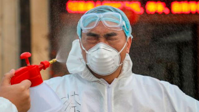 Esta foto muestra a un médico desinfectado por su colega en una zona de cuarentena en Wuhan. Foto: AFP.