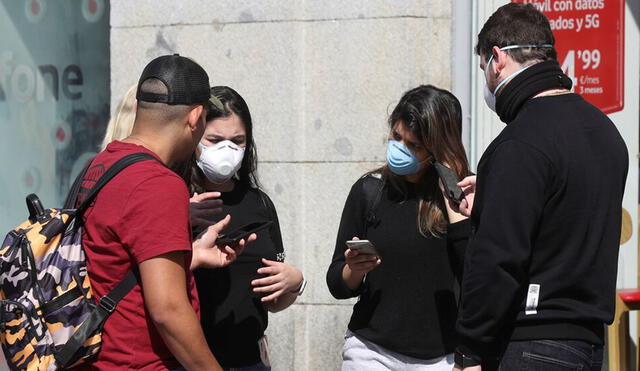 Un grupo de jóvenes manipula sus celulares. Este descuido puede desencadenar un contagio por la contaminación del objeto | Foto: Agencia EFE.