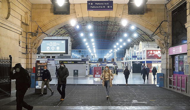 Viajeros en la estación Victoria, de Londres. Ayer se tomaron restricciones más severas, tras el aumento de casos por una nueva cepa más infecciosa del
coronavirus. Foto: AFP