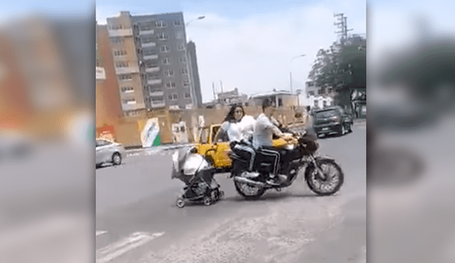 Padres arrastran cochecito de bebé desde una motocicleta