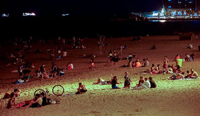 Varios jóvenes en una playa de Barcelona (España), tras el cierre de discotecas decretado por las autoridades catalanas para evitar la propagación del coronavirus. Foto: EFE