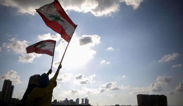 Dos mujeres ondean la la bandera del Líbano. Foto: AFP.
