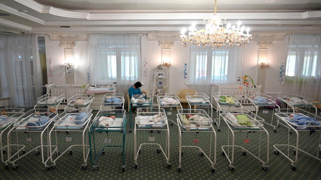 A nurse cares for newborn babies at Kiev's Venice hotel on May 15, 2020. - More than 100 babies born to surrogate mothers have been stranded in Ukraine as their foreign parents cannot collect them due to border closures imposed during the coronavirus pandemic, authorities said on May 14. (Photo by Sergei SUPINSKY / AFP)
