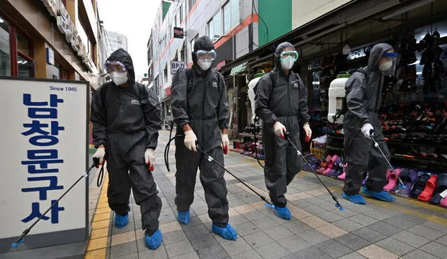 South Korean health officials from Bupyeong-gu Office wearing protective gear, spray disinfectants at a shopping district in Incheon on September 17, 2020 amid the new COVID-19 coronavirus pandemic. - South Korea -- which largely overcame an early Covid-19 surge with extensive tracing and testing -- has seen several clusters in recent weeks, raising concerns of a second wave and prompting authorities to tighten social distancing measures last month. (Photo by Jung Yeon-je / AFP)