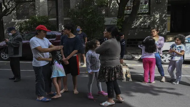 People are seen on a street during a quake in Mexico City, on June 23, 2020. - A 7.1 magnitude quake was registered Tuesday in the south of Mexico, according to the Mexican National Seismological Service. (Photo by RODRIGO ARANGUA / AFP)
