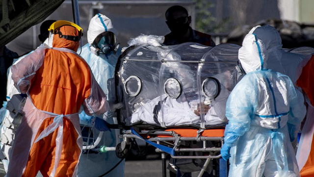 Health workers move a COVID-19 infected patient to a C-130 Hercules, to be taken to the city of Concepcion, at a Chilean Air Force base in Santiago, Chile, on May 24, 2020. - Patients infected with COVID-19 are taken to other cities in the country in order to free up space in the intensive care units of hospitals in Santiago. (Photo by MARTIN BERNETTI / AFP)