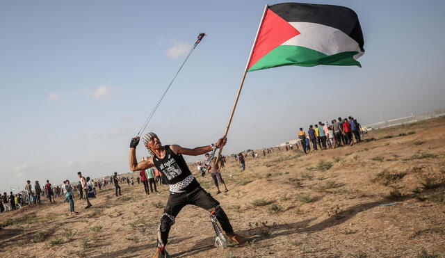 Gaza Strip (---), 12/07/2019.- A protester carries the Palestinian flag as he hurls stones with a slingshot near the border between Israel and the Gaza Strip, in the eastern Gaza Strip, 12 July 2019. (Protestas) EFE/EPA/MOHAMMED SABER