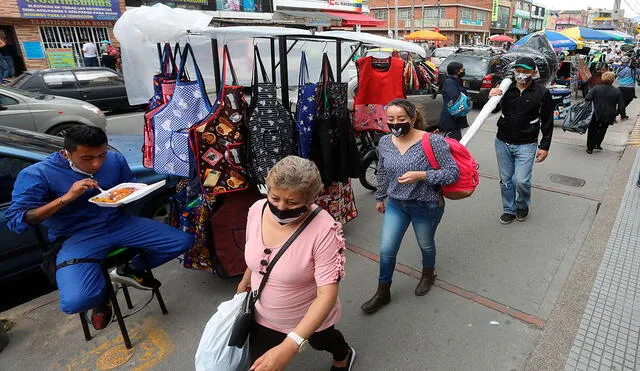 Personas caminan por una zona comercial en el barrio La Alquería de Bogotá. La capital, con 256.116 casos de COVID-19, permanece como la ciudad con la mayor cantidad de contagios de Colombia. Foto: AFP