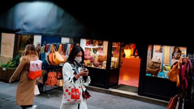 Mujer camina por las calles de París con una mascarilla para protegerse del COVID-19. Foto: AFP.