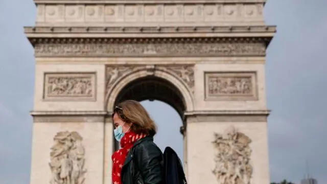 Una mujer con mascarilla camina por el Arco del Triunfo de París. Foto: Europa Press