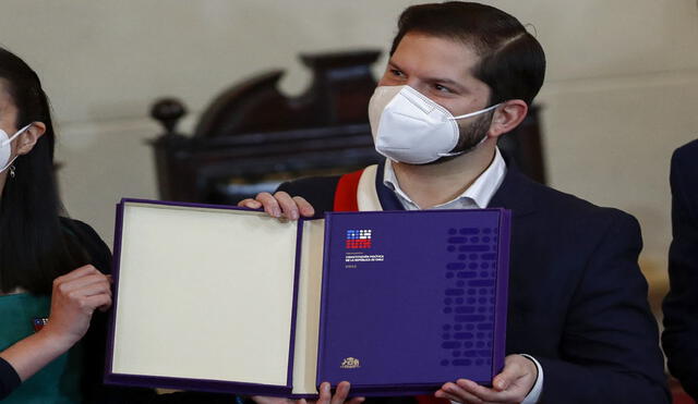 El presidente de Chile, Gabriel Boric, sostiene el proyecto final de la propuesta constitucional durante su presentación en el Congreso Nacional en Santiago, el 4 de julio de 2022. Foto: AFP