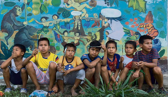 Colores. Niños de la comunidad muruy bora junto al mural que pintaron en Iquitos con el artista amazónico Brus Rubio. Foto: difusión
