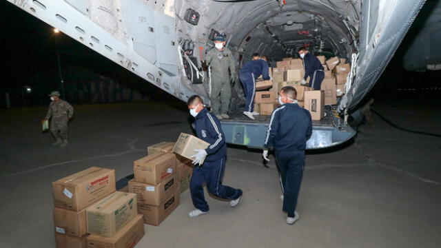 Miembros de la Fuerza Aérea descargan las cajas enviadas en el vuelo.