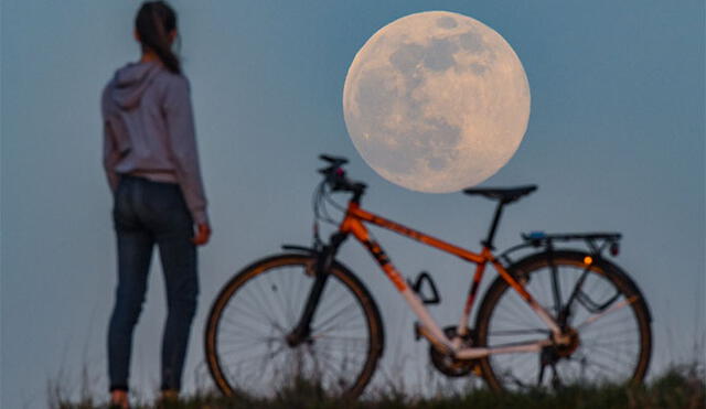 Ciclista se detiene a observar la superluna en Alemania. Foto: AFP.