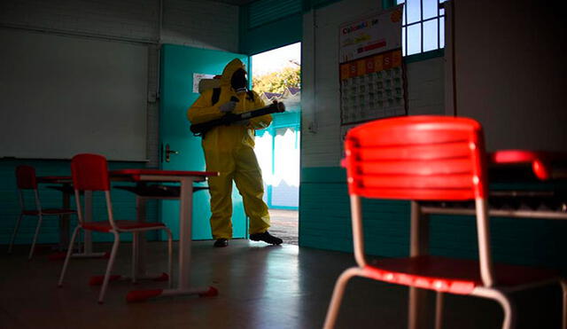 Un trabajador desinfecta este jueves una escuela públicas en Brasilia (Brasil), donde se preparan para el regreso de las clases presenciales para finales de agosto. Foto: EFE