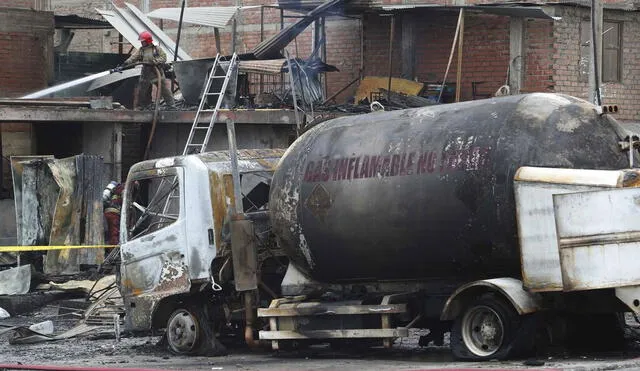 Un bombero enfría con agua el techo de un camión cisterna de gas que explotó en el barrio de Villa María en Lima, Perú, el jueves 23 de enero de 2020. La explosión dejó dos muertos, aproximadamente 50 personas heridas y al menos una docena de casas quemadas. (AP Foto / Martín Mejía)