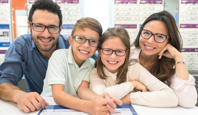 Portrait of a happy Latin American family trying on glasses at the optical shop and smiling â?? lifestyle concepts