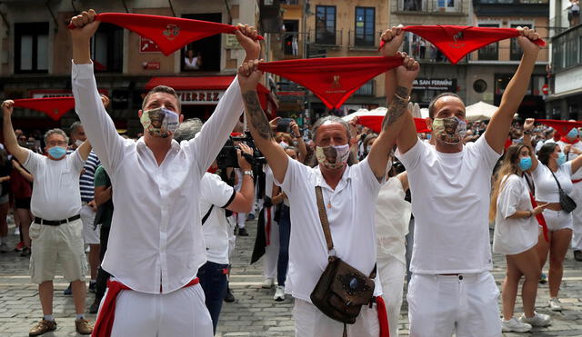 Revellers hold up traditional red scarves in front of the town hall where the firing of "chupinazo", which opens the San Fermin festival that was cancelled due to the coronavirus disease (COVID-19) outbreak, should have taken place, in Pamplona, Spain July 6, 2020. REUTERS/Jon Nazca