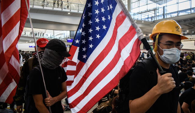 Manifestantes portan banderas de Estados en el aeropuerto internacional de Hong Kong.