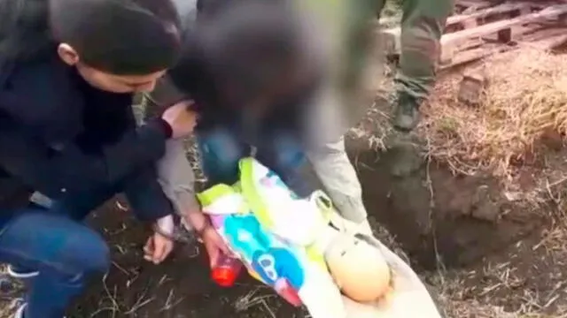 En la reconstrucción del crimen, Yulia usó una muñeca para mostrar cómo estranguló y enterró a su hijo de un año. Captura de video: Daily Mail.