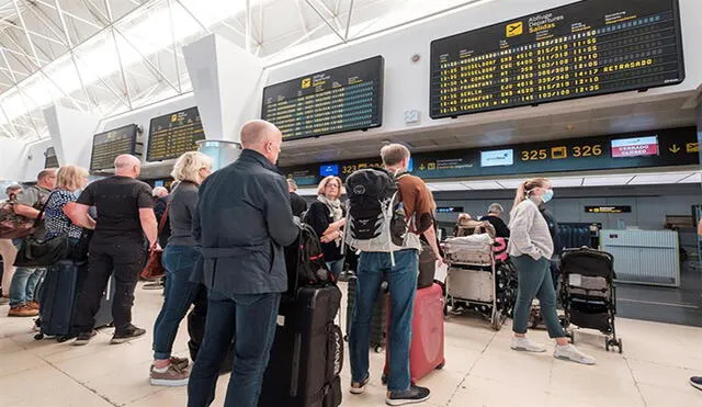 Varias personas esperan su turno en el aeropuerto de Gran Canaria, España, que este domingo funciona con total normalidad. Foto: EFE