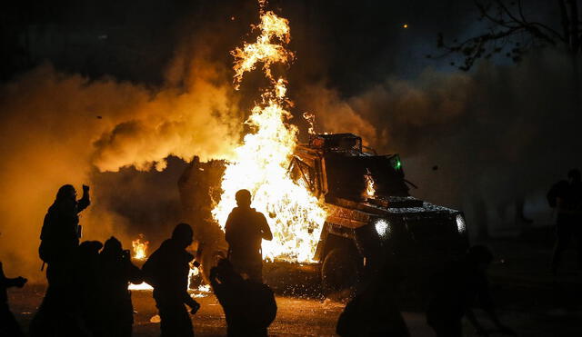 Los manifestantes queman un vehículo de la policía antidisturbios durante los enfrentamientos. Foto: AFP
