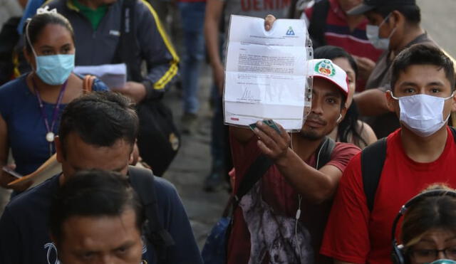 Un trabajador en un paradero muestra su permiso para circular. Crédito: La República