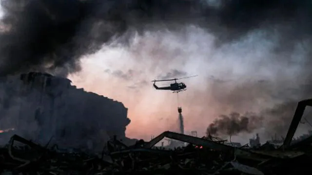 Un helicóptero apaga el incendio en el lugar de la explosión en el puerto de Beirut. Foto: AFP.