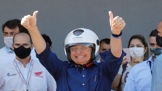 Brazilian President Jair Bolsonaro gestures after going out for a ride and having his motorcycle's engine overhaul after he announced he tested negative for COVID-19 more than two weeks after being diagnosed, in Brasilia, on July 25, 2020, during the novel coronavirus pandemic. (Photo by Sergio LIMA / AFP)