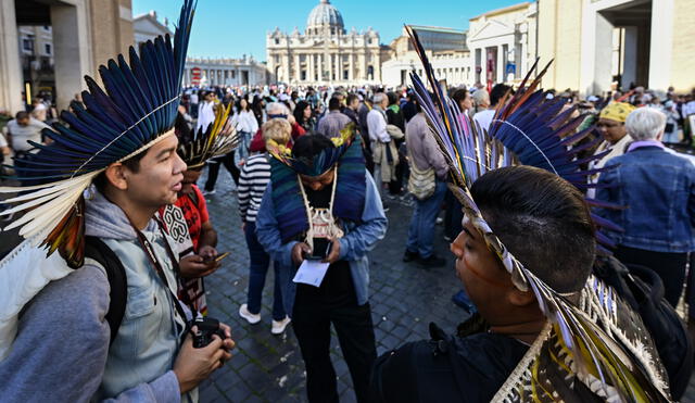 Indigenous leaders talks as they take part in a procession with prelates and people participating in the Special Assembly of the Synod of Bishops for the Pan-Amazon Region, on October 19, 2019 between Rome's Castel Sant'Angelo and the Vatican's St. Peters Square (Rear). - Pope Francis is gathering Catholic bishops at the Vatican to champion the isolated and poverty-struck indigenous communities of the Amazon, whose way of life is under threat. (Photo by Vincenzo PINTO / AFP)