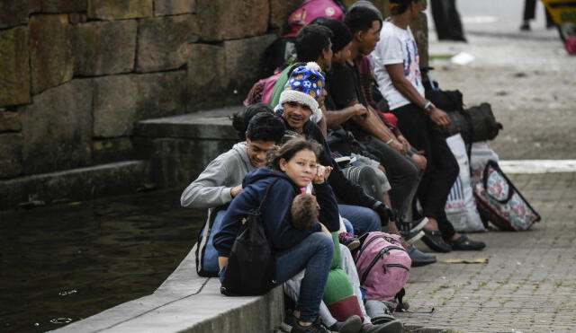 Venezuelan migrants rest at a park in Bucaramanga, Colombia, on December 17, 2019. - Venezuelan migrants in Colombia undertake a round trip to their country with the desire to spend Christmas at home. (Photo by Juan BARRETO / AFP)