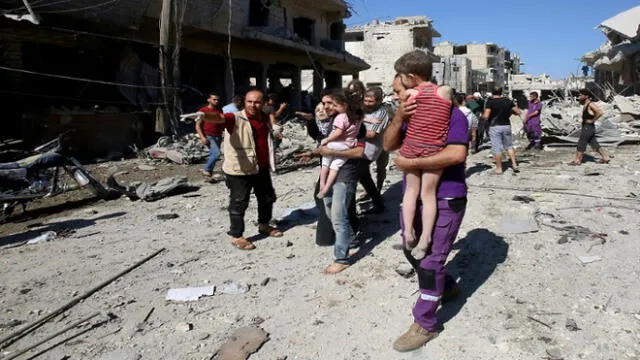 Un miembro de una oenegé humanitaria evacúa a un niño tras supuestos bombardeos rusos contra Maaret al Numan, ciudad del noroeste de Siria, el 22 de julio de 2019