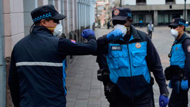 Oficiales se saludan con el codo para evitar la propagación del coronavirus. Foto: AFP.