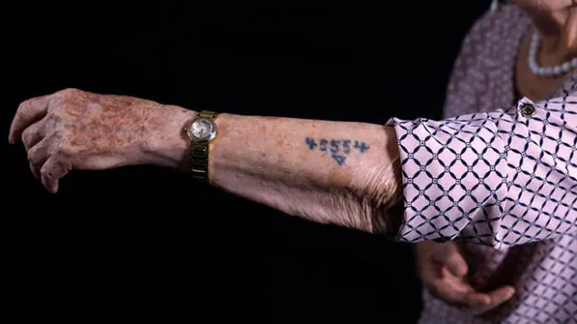 Una de las sobrevivientes a los campos de concentración de Auschwitz mostrando el tatuaje con que los marcaban. Foto: AFP