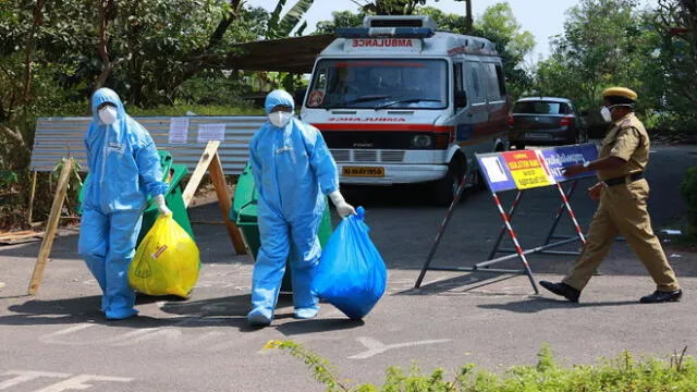 Heath officials in full protective apparel carry medical waste out of an isolation ward of Ernakulam medical, where 12 suspected SARS-like virus patients are kept in quaratine, in Kochi on February 4, 2020. - The new coronavirus that emerged in a Chinese market at the end of last year has killed more than 360 people and spread around the world. (Photo by Arun CHANDRABOSE / AFP)